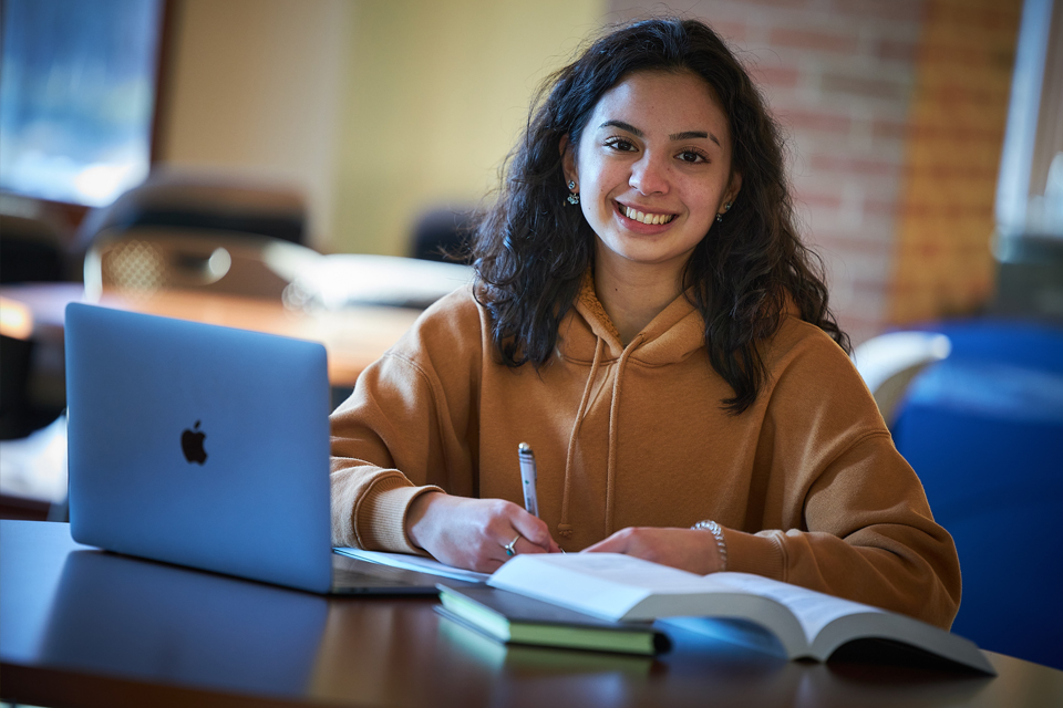 student on laptop smiling