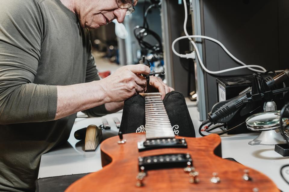 male student working on a guitar