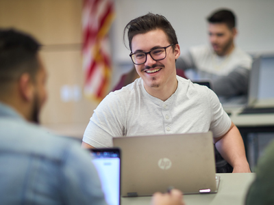 smiling man in front of computer