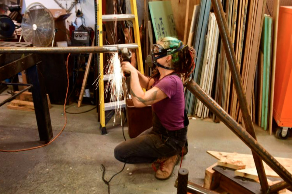 NCC Alum filing a tube of metal for a sculpture