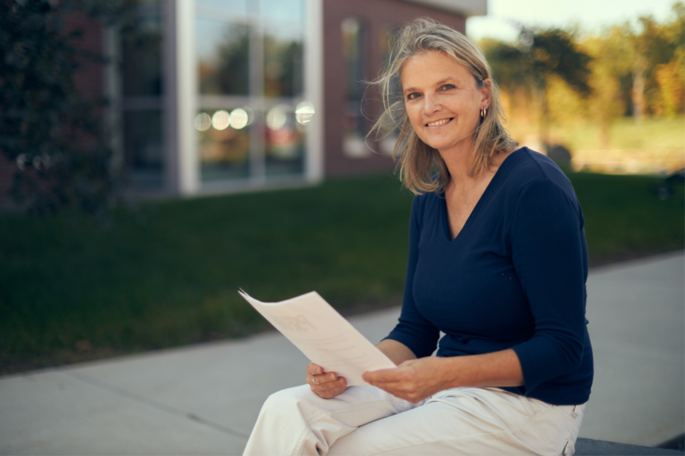 Adult student sitting on wall