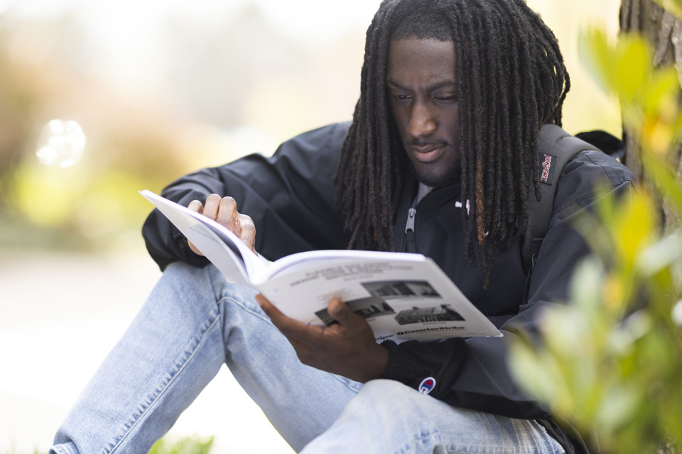 Student reading a book outside