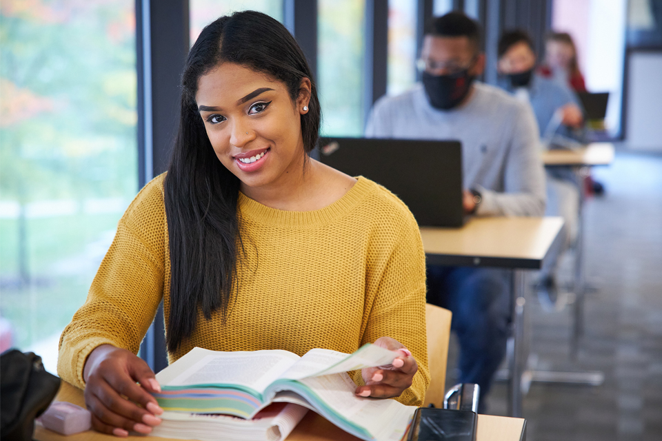 Student smiling at her desk