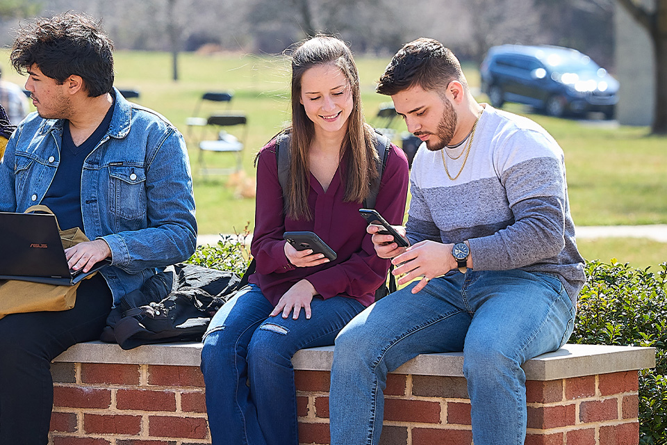 students sitting on wall