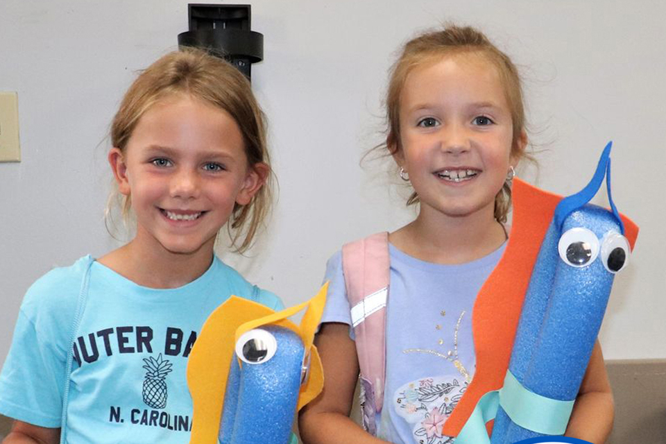 Two girls posing with crafts they made in Horizons for Youth