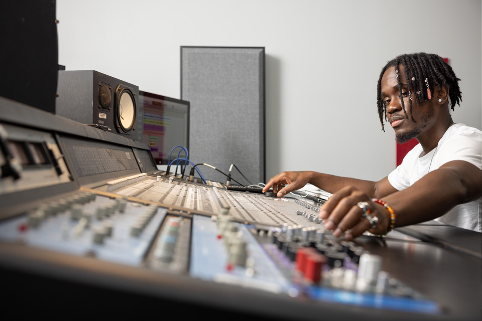 media student behind a control board