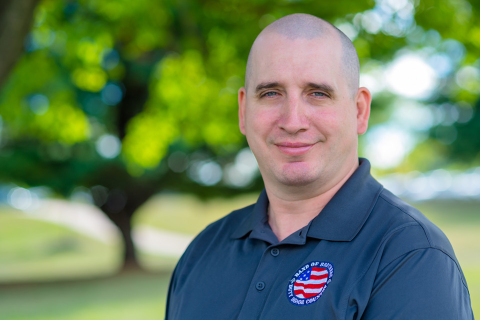 Adult male student wearing a military affiliated shirt outside