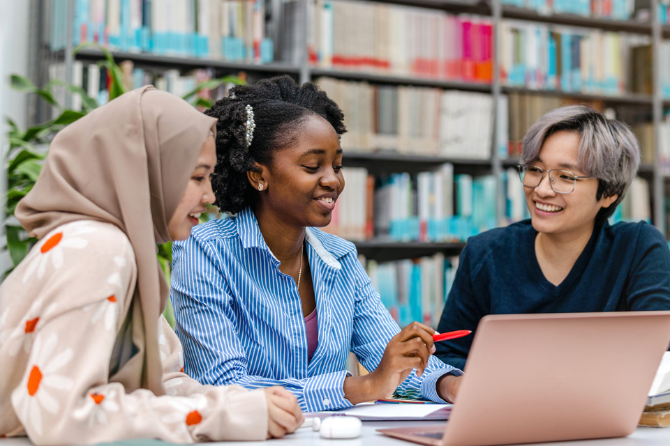 Students discussing information on a laptop