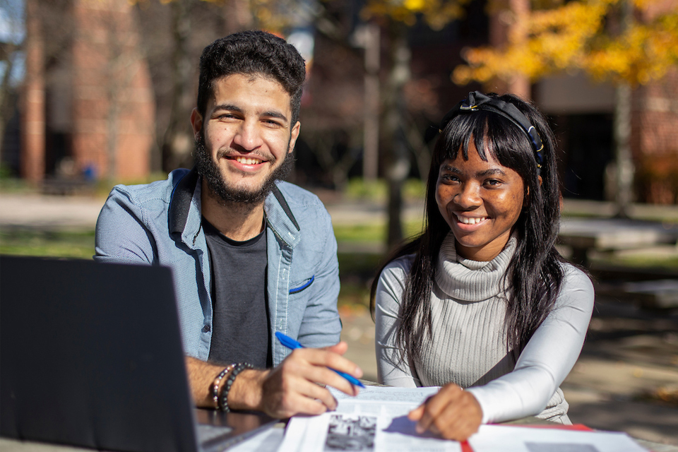 students smiling at their laptop