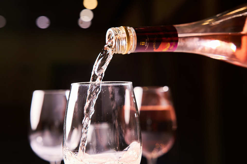 rose wine being poured into a glass