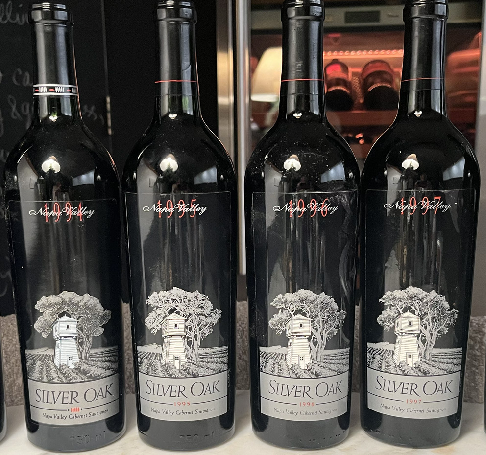 Several red wine bottles lined up on a table