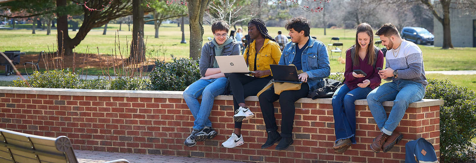students on brick wall sitting